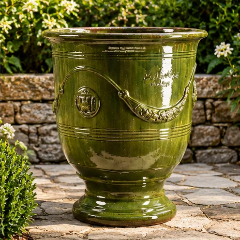 Dark green pedestal planter with raised garland and medallion details