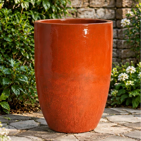 Tall rounded planter with a warm reddish glazed finish
