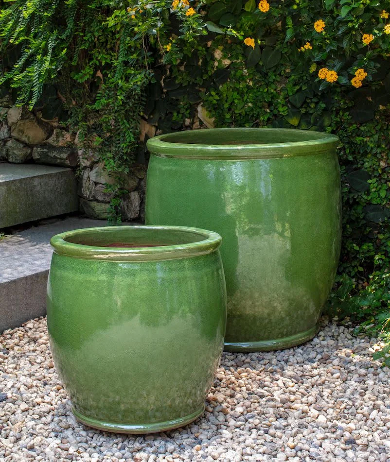Pair of rounded green planters arranged in a garden